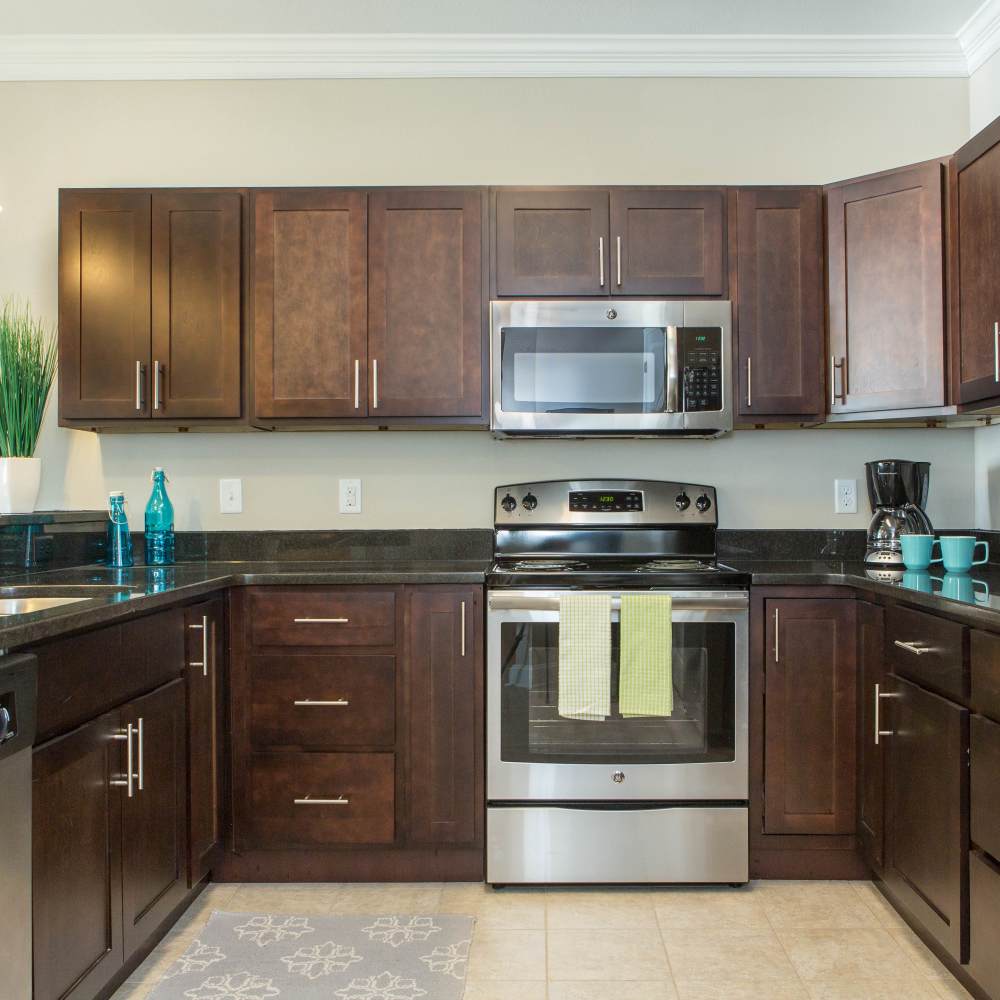 Kitchen with walnut color cabinet  at The Apartments at Goose Creek in Fishersville, Virginia