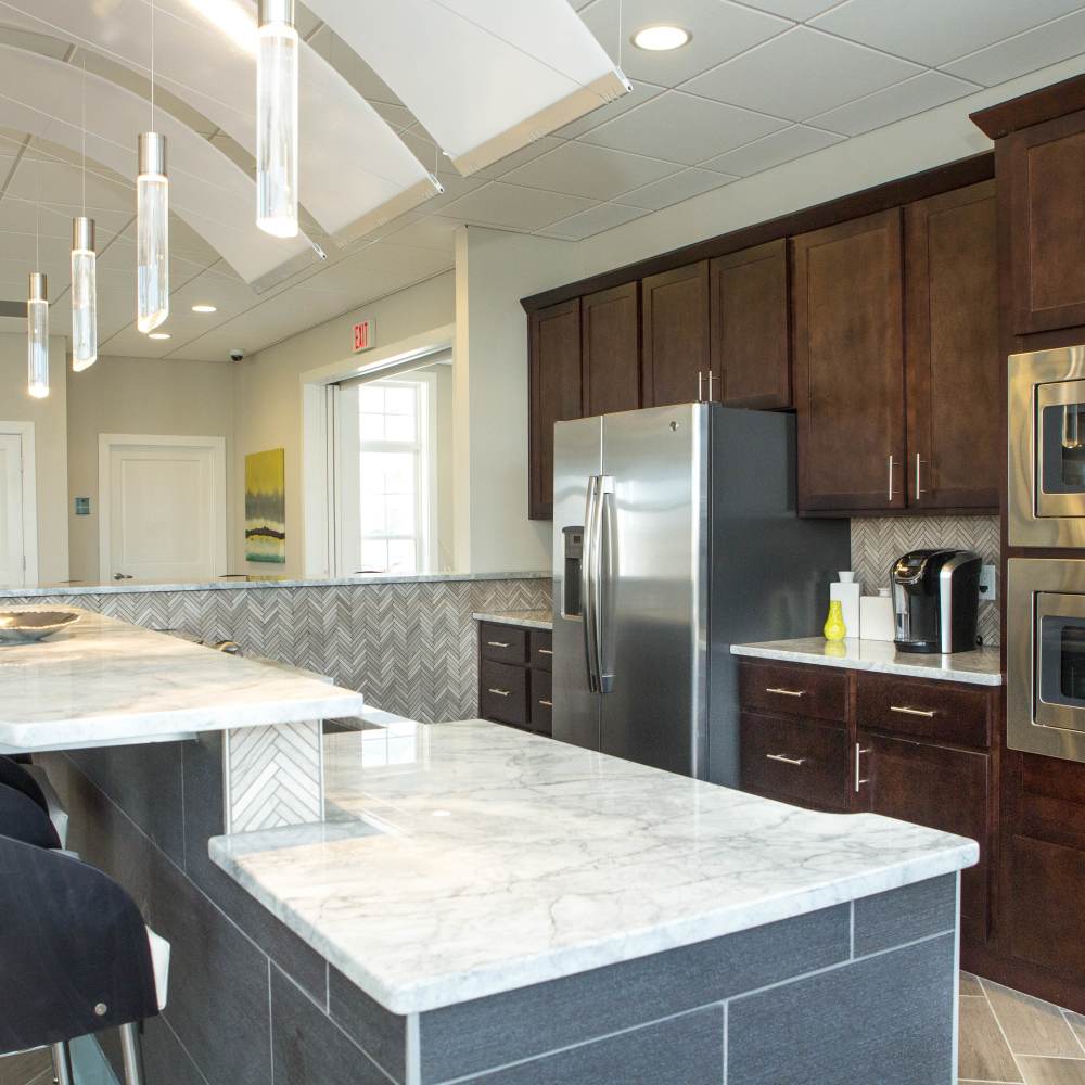 Clubhouse kitchen with breakfast countertop at The Apartments at Goose Creek in Fishersville, Virginia