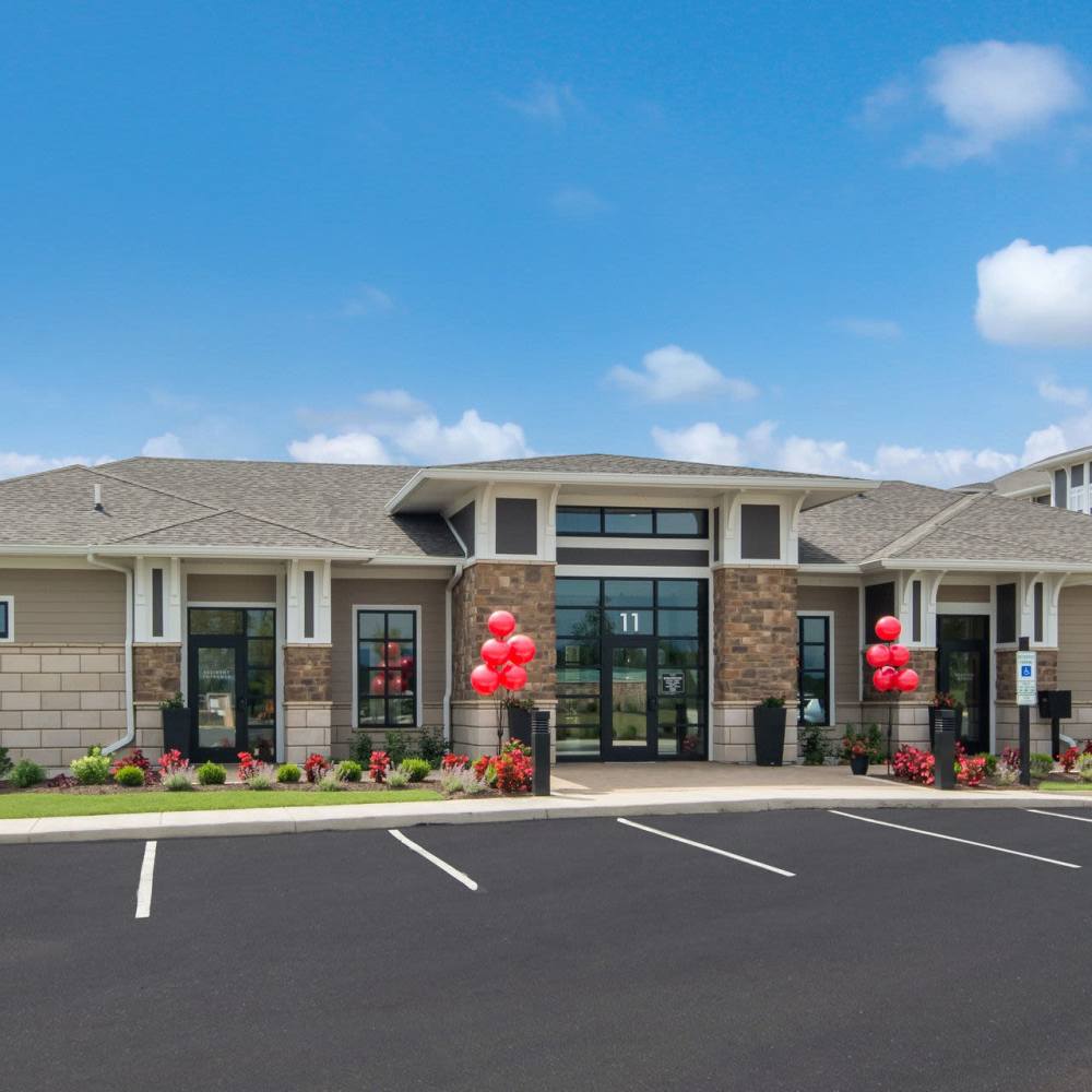 Exterior view of the community building with parking spaces at The Knoll at Stone View in Ruckersville, Virginia