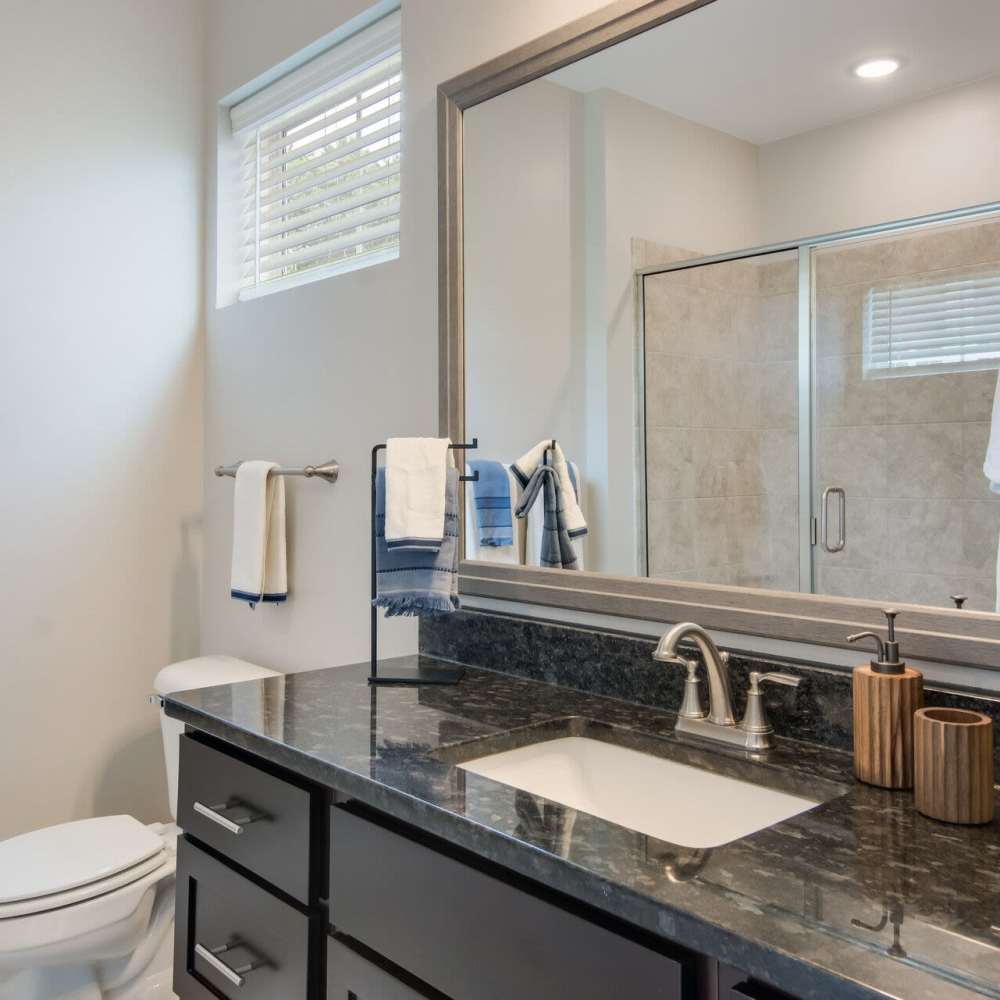 Bathroom with vanity mirror at The Apartments At Kelton Station in Williamsburg, Virginia