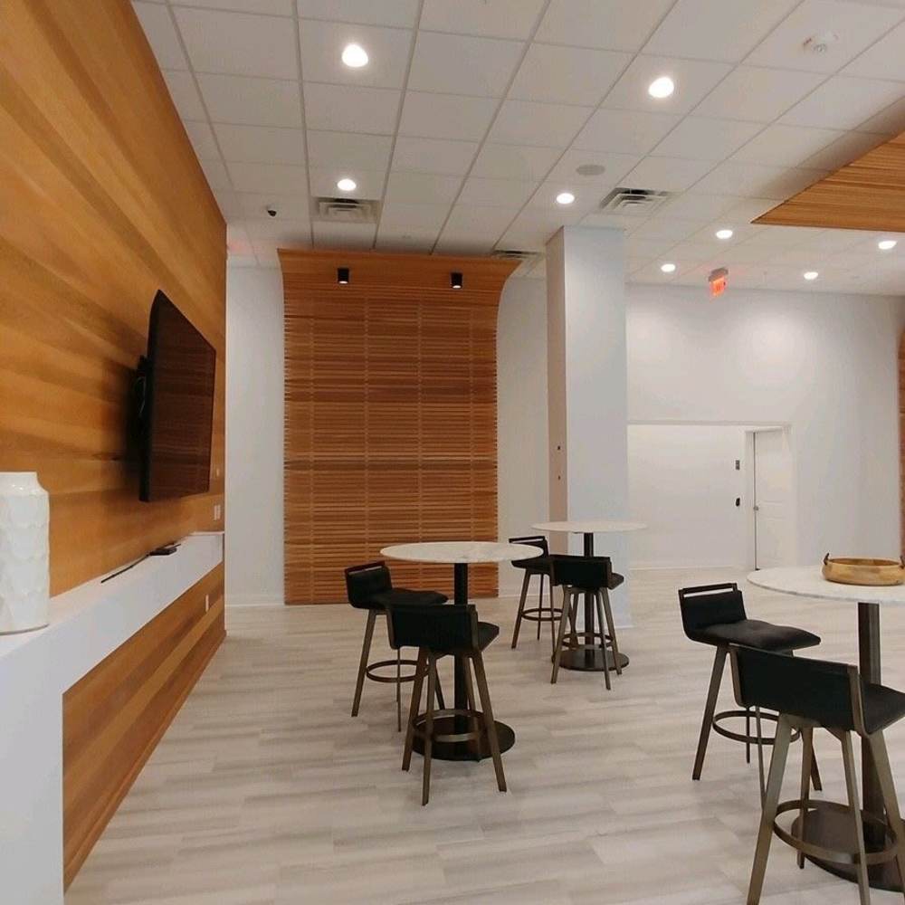 Community room with a TV and multiple tables and chairs at The Summit At Old Trail in Crozet, Virginia 