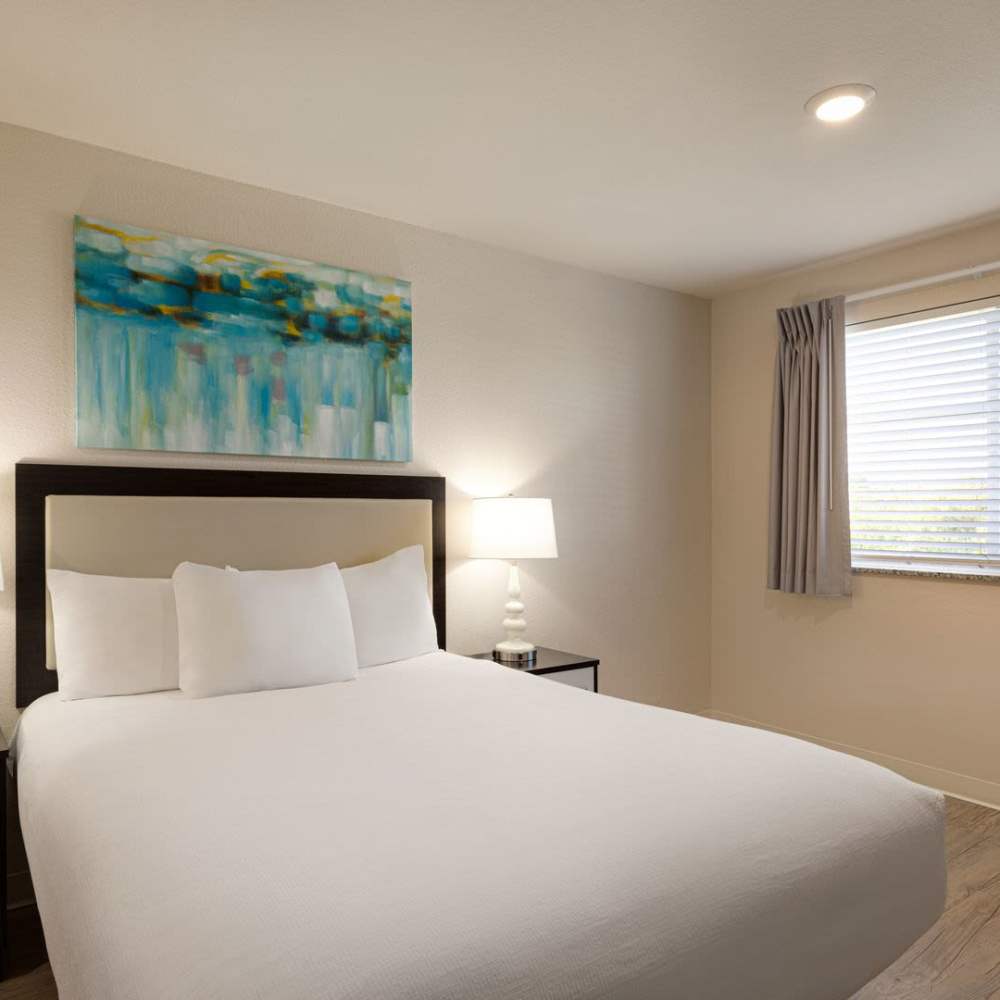 White bed  with wall art at WaterWalk Raleigh - RTP in Morrisville, North Carolina