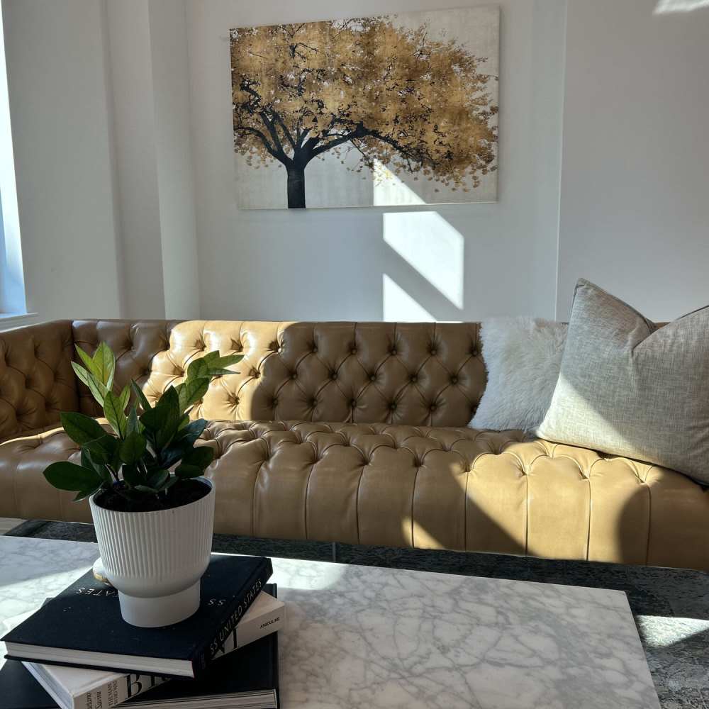 Stylish living room with tufted leather sofa at The Summit At Old Trail in Crozet, Virginia