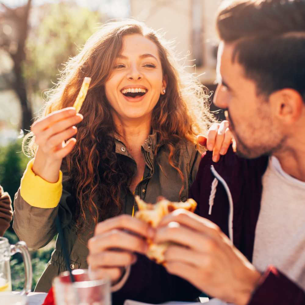 Friends enjoying food and laughter near Niner Woods in Charlotte, North Carolina