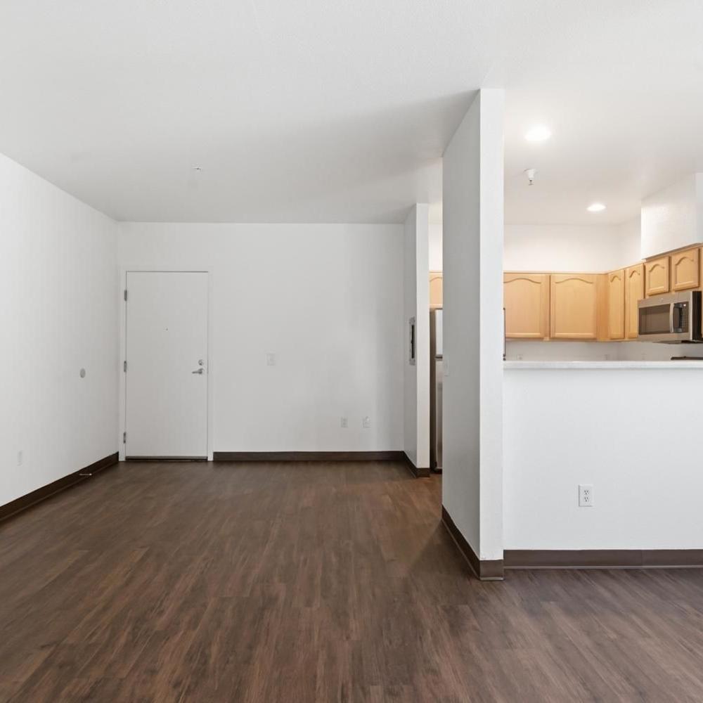 Open dining space with wood floors, white walls and kitchen opening at Market Gateway in San Jose, California