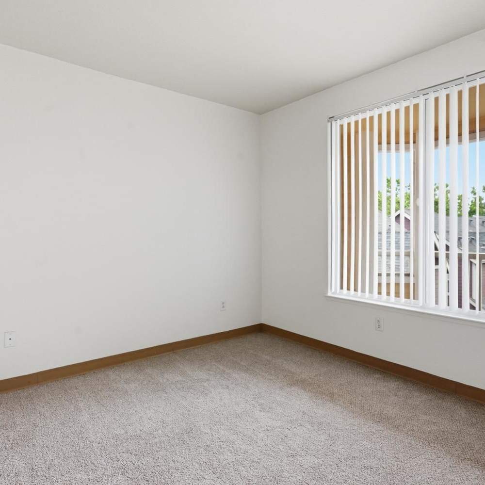 Bedroom with carpet flooring, corner window, and vertical blinds at Market Gateway in San Jose, California