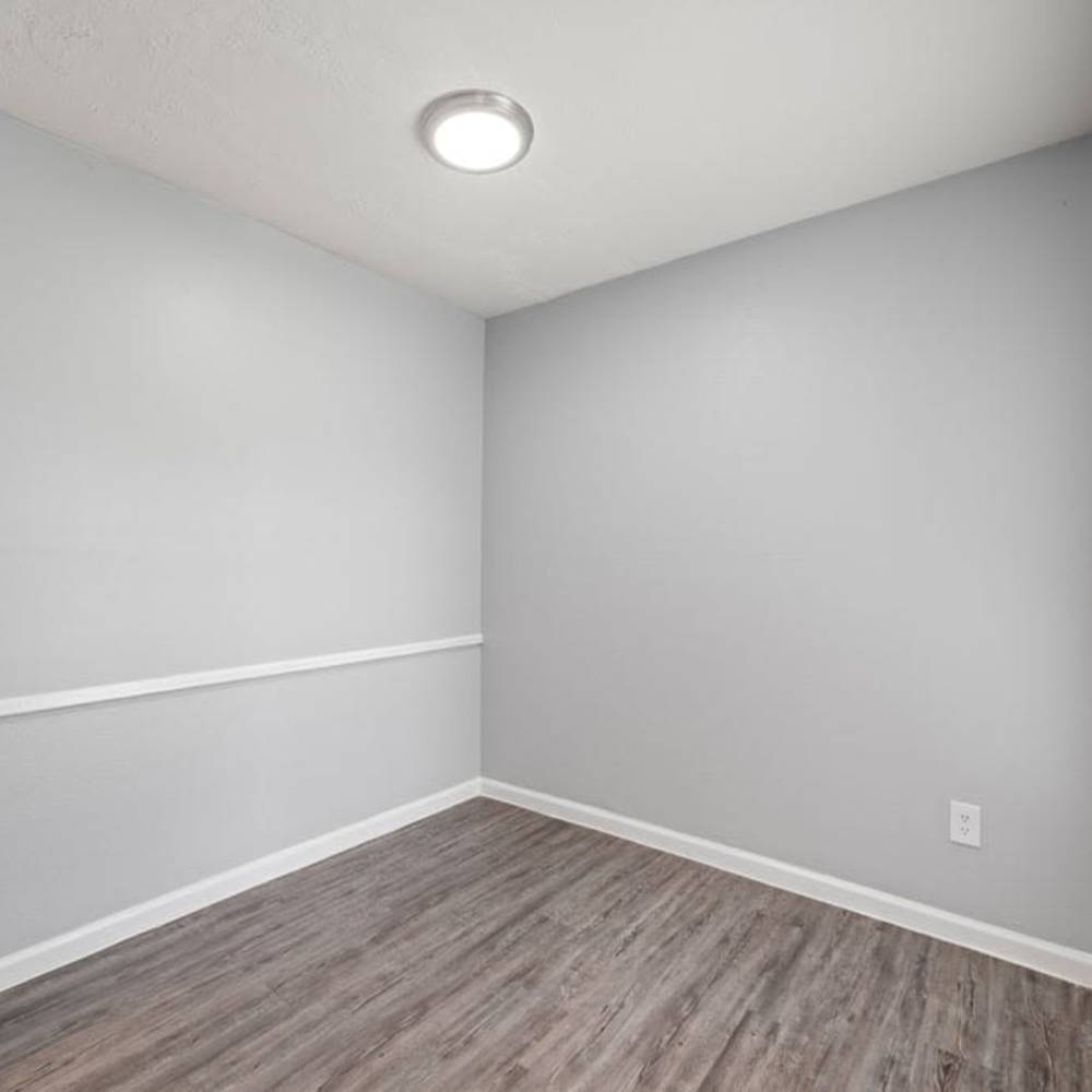 Small room with wood-style flooring, overhead light, and window blinds at The Montclair in Houston, Texas