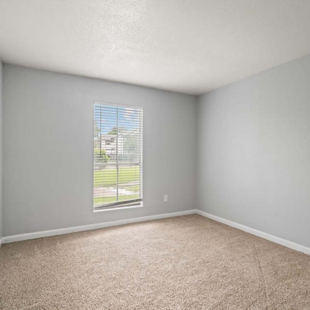 Bedroom with carpet flooring, window with blinds, and natural light at The Montclair in Houston, Texas