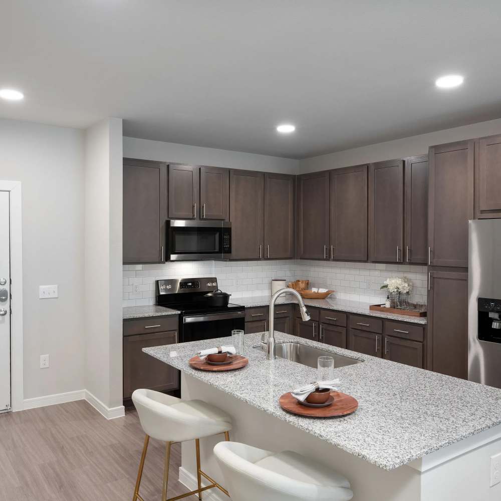 Open layout kitchen with granite countertops at August Friendswood in Friendswood, Texas
