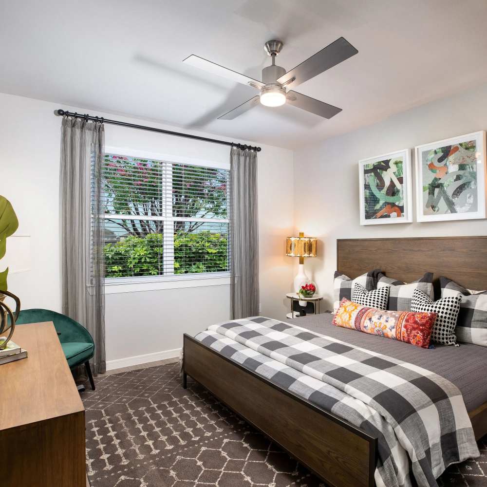 Cozy bed with patterned throw pillows at August Friendswood in Friendswood, Texas
