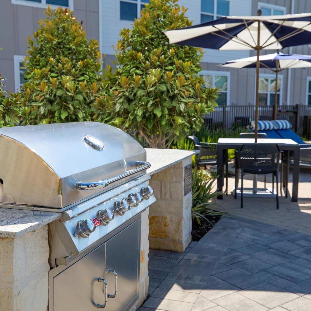 Stainless steel grill with outdoor seating at August Friendswood in Friendswood, Texas