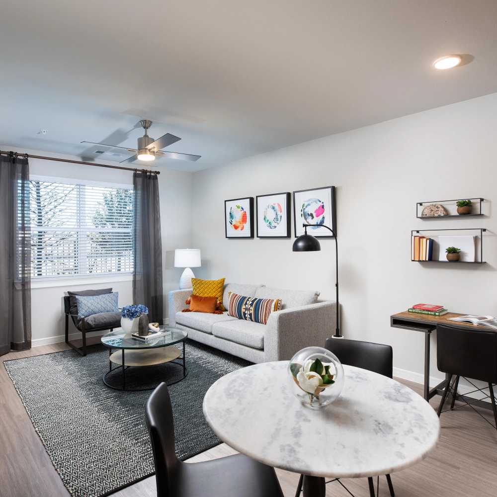 Living room with modern decor and dining area at August Friendswood in Friendswood, Texas