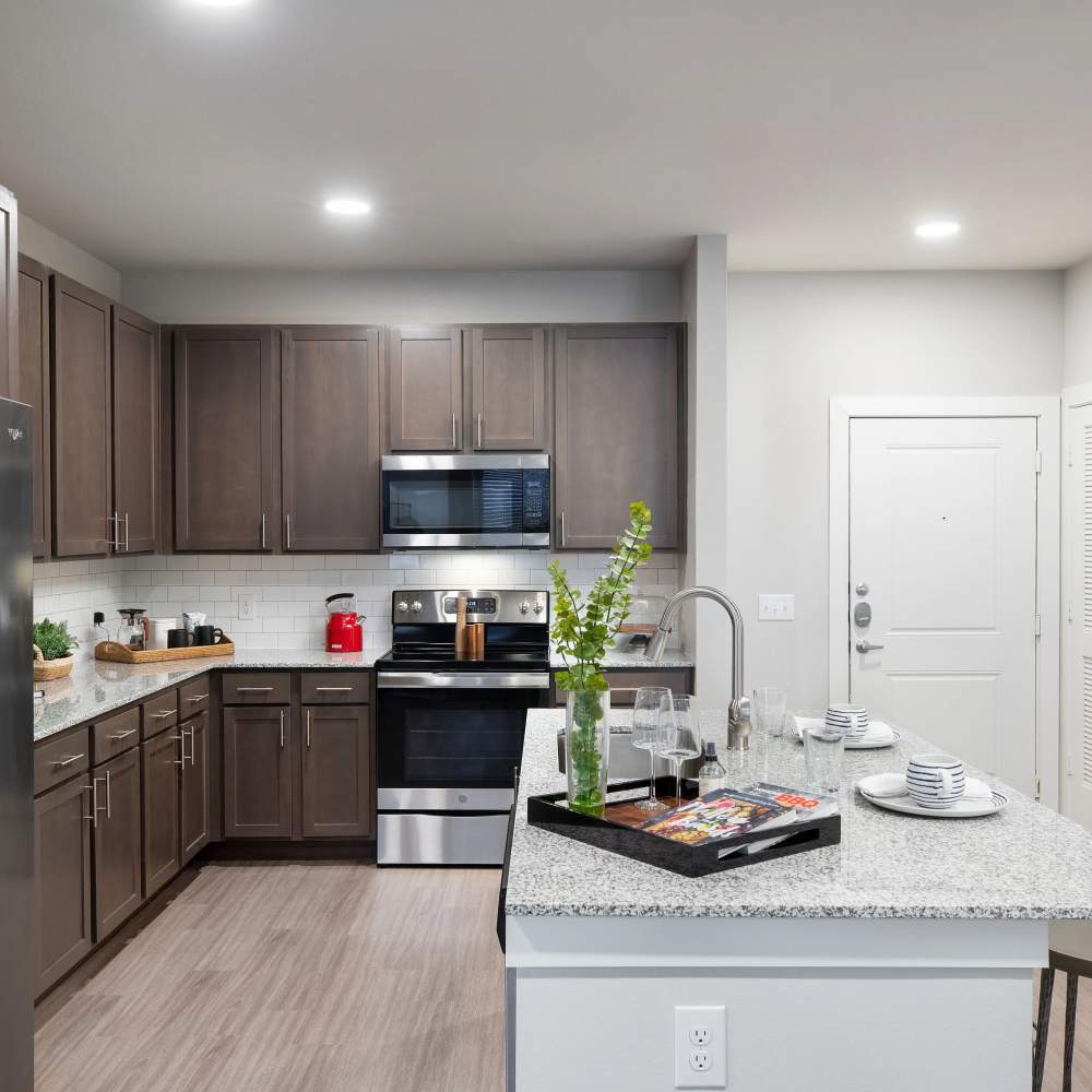 Modern kitchen with granite countertops at August Friendswood in Friendswood, Texas
