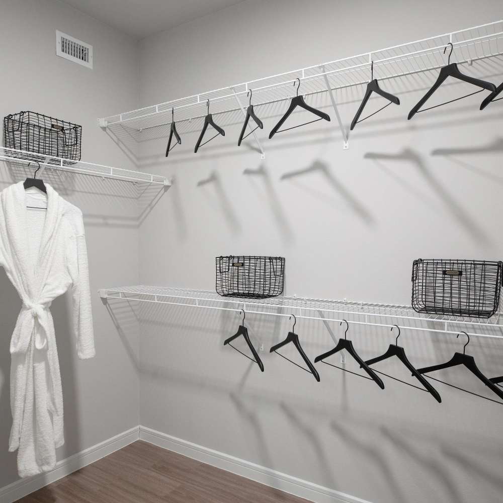 Cozy white robe hanging in spacious closet at August Friendswood in Friendswood, Texas