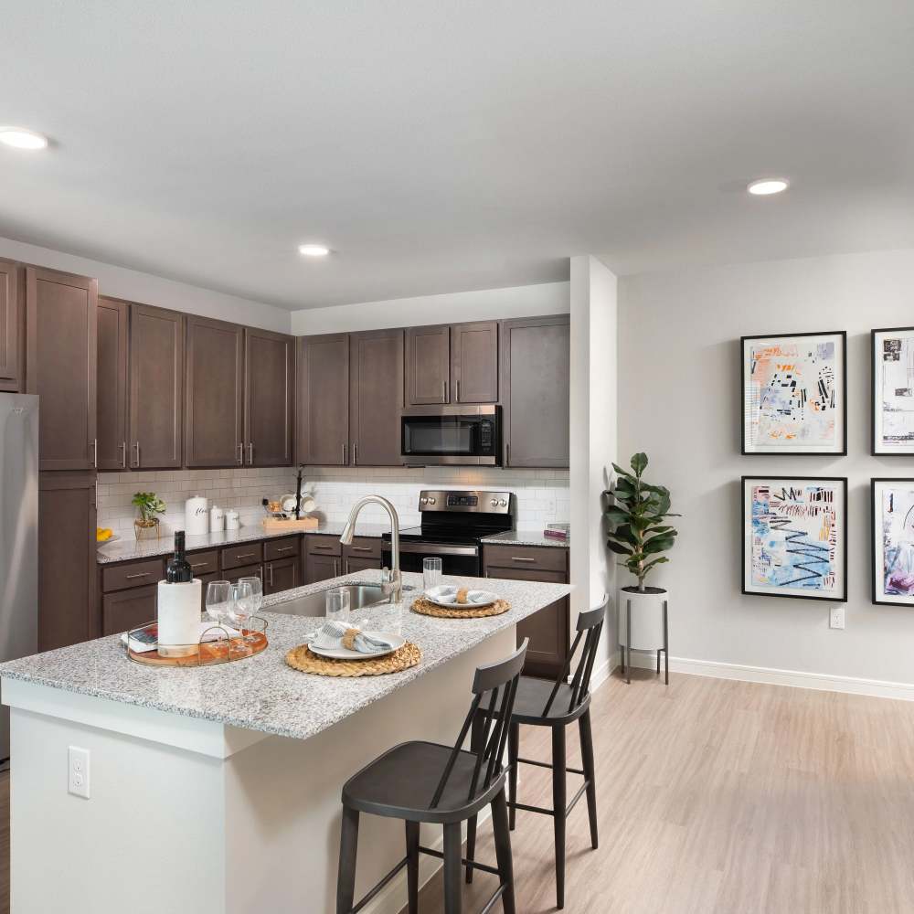 Modern kitchen with granite island at August Friendswood in Friendswood, Texas