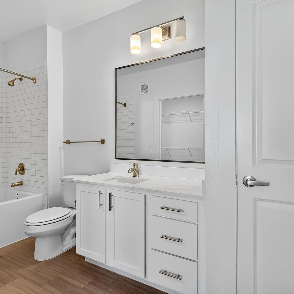 Modern bathroom with white cabinetry at August Friendswood in Friendswood, Texas