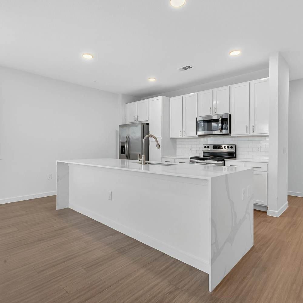White island with stainless steel appliances at August Friendswood in Friendswood, Texas