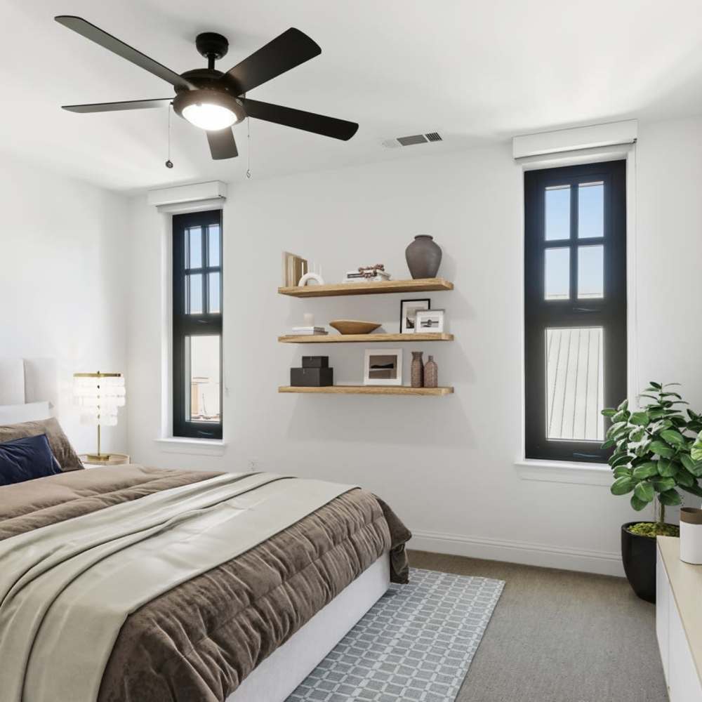 Modern bedroom with a wall-mounted TV and large windows.