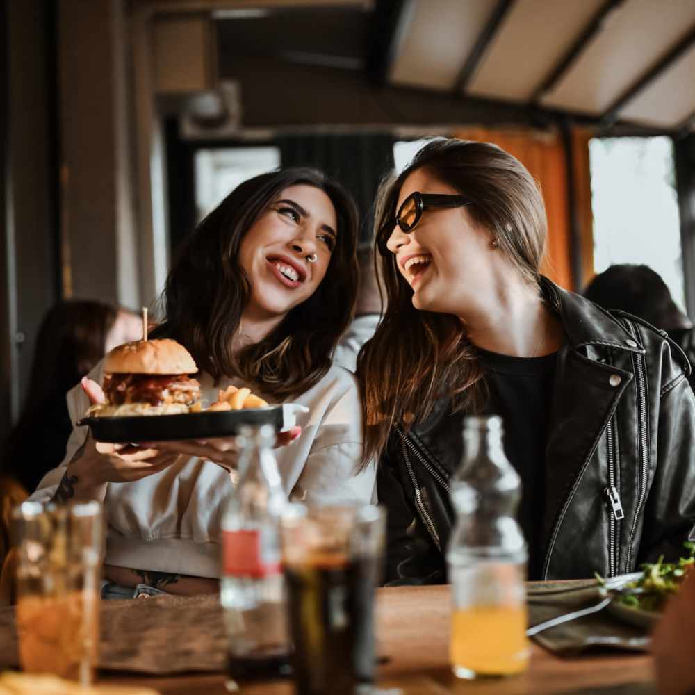 Two residents enjoying a meal and beverages together near Titan Court in Eugene, Oregon