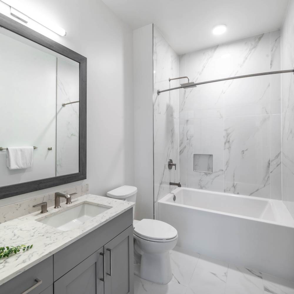 Modern bathroom with marble tile at Novel Turtle Creek in Dallas, Texas