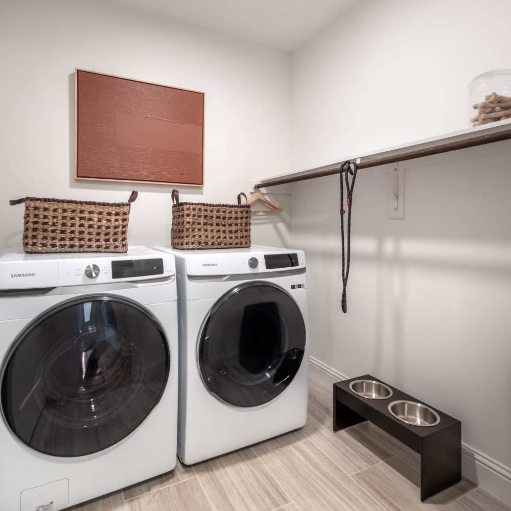 Laundry room with stacked washer and dryer at Novel Turtle Creek in Dallas, Texas