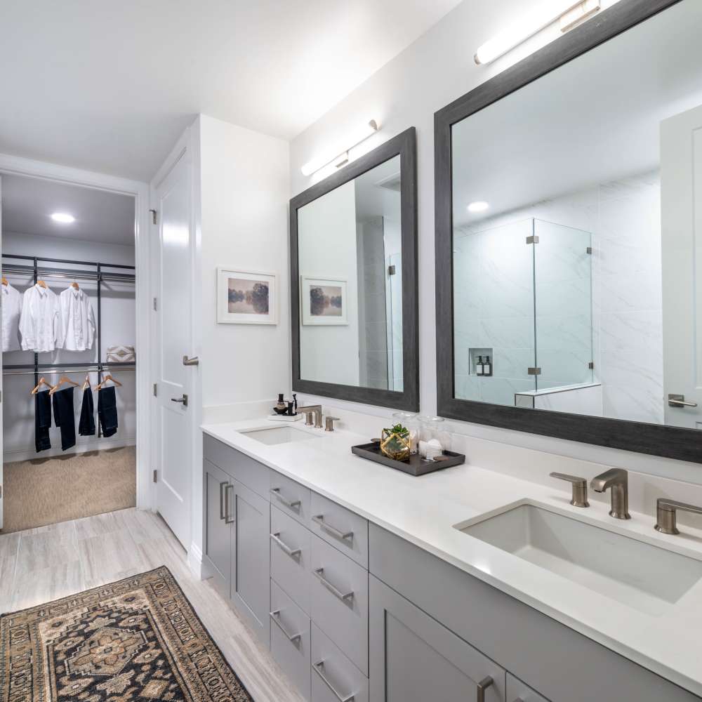 Modern bathroom with double sinks and large mirrors at Novel Turtle Creek in Dallas, Texas