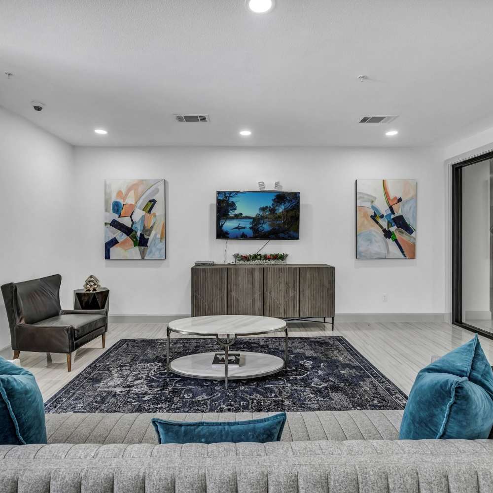 Modern living room with wood-style flooring and large TV at The Milo on Westheimer in Houston, Texas