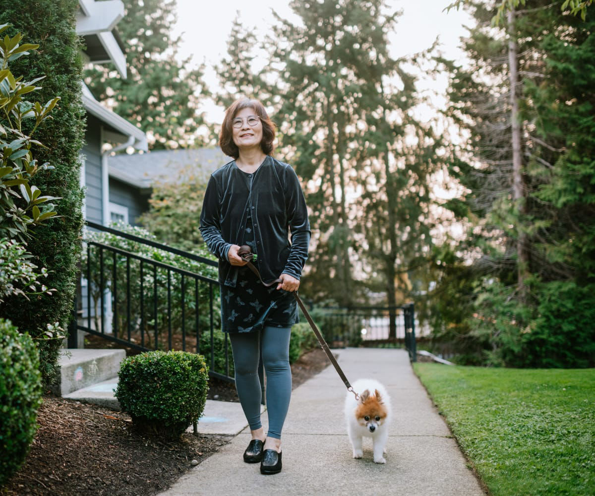Resident walking her dog outside at Carriage Inn Lake Jackson in Lake Jackson, Texas