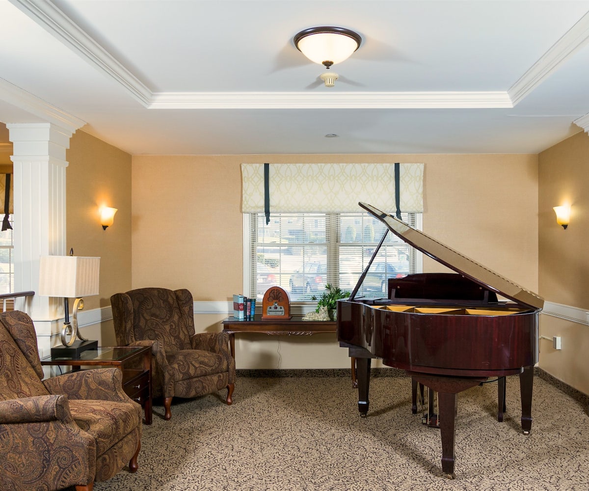 Multipurpose room with piano at Pacifica Senior Living Victoria Court in Cranston, Rhode Island