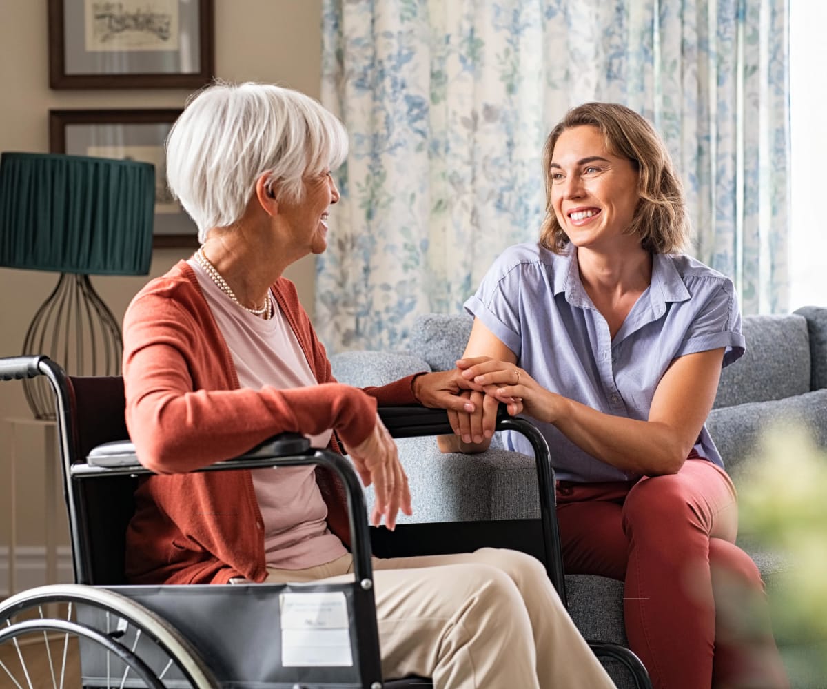 Resident in a wheelchair talking to a therapist at Carriage Inn Katy in Katy, Texas
