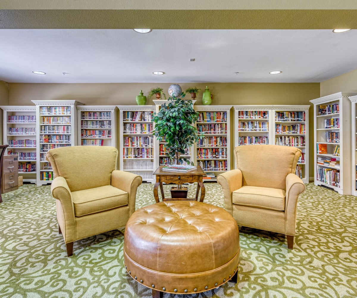 Resident library with lounge chairs at Pacifica Senior Living Menifee in Sun City, California