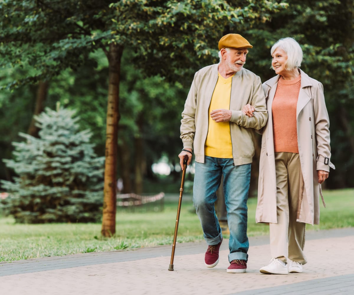 Residents out for a walk with forest in the background at Lake Park Senior Living in Oakland, California