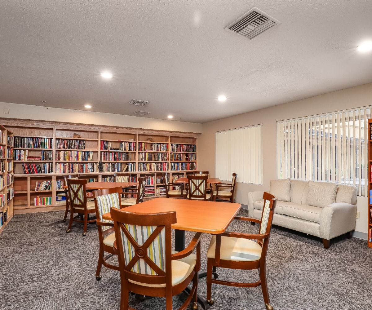 Resident library with many bookshelves and seating at Pacifica Senior Living Poway in Poway, California