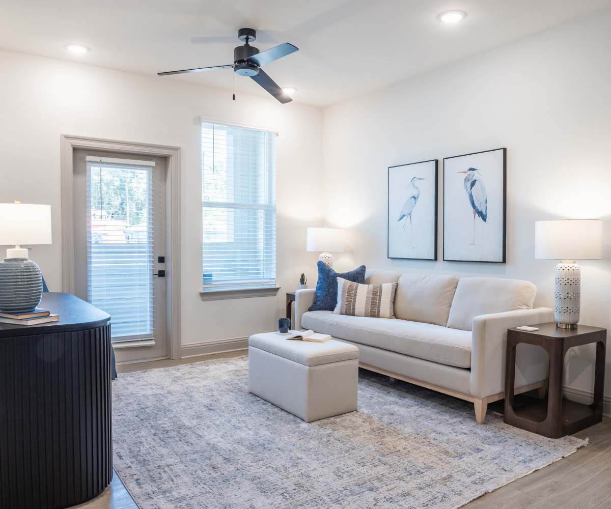 Carpeted Living Room with Glass Center Table at The Waters at Freeport in Freeport, Florida