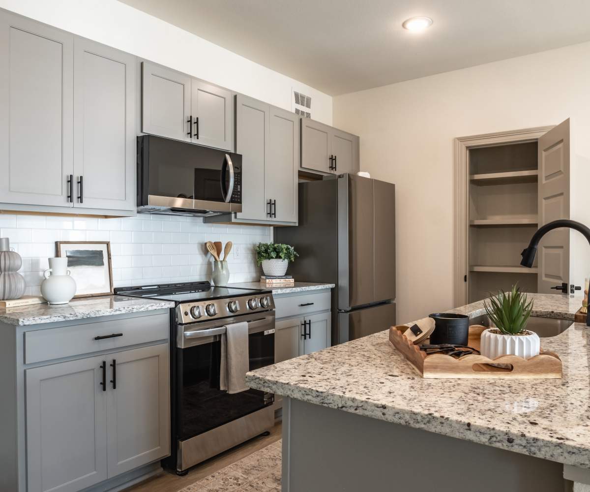 Kitchen with Stainless steel appliances and gray cabinetry at The Waters at Freeport in Freeport, Florida