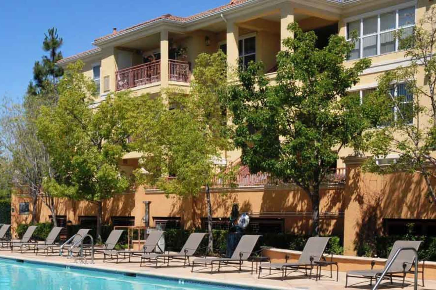 Enjoy a swimming pool with lounge chairs at The Carlyle in Santa Clara, California