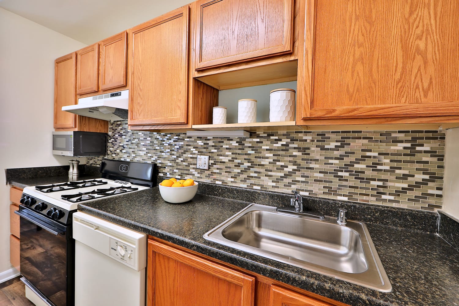 Contemporary kitchen with tile backsplash at Cedar Creek Apartment Homes in Glen Burnie, Maryland