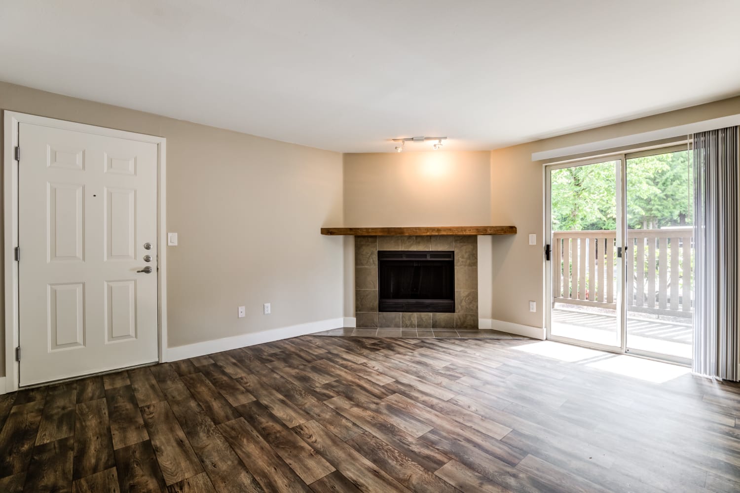  a Living Room with fireplace, hardwood floors and patio access at Campbell Run Apartments in Woodinville, Washington