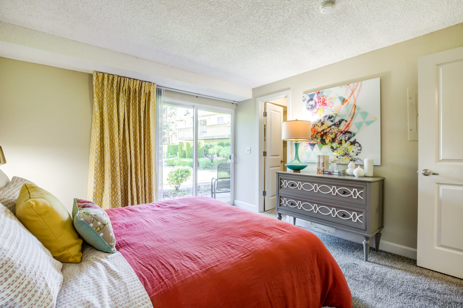 Spacious bedroom with sliding door to patio space at Edgewood Park Apartments in Bellevue, Washington