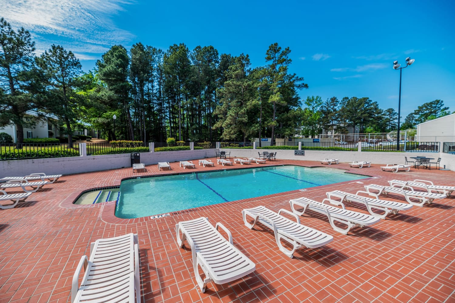 Swimming pool surrounded by lounge chairs at Traditions at Augusta Apartment Homes in Augusta, Georgia