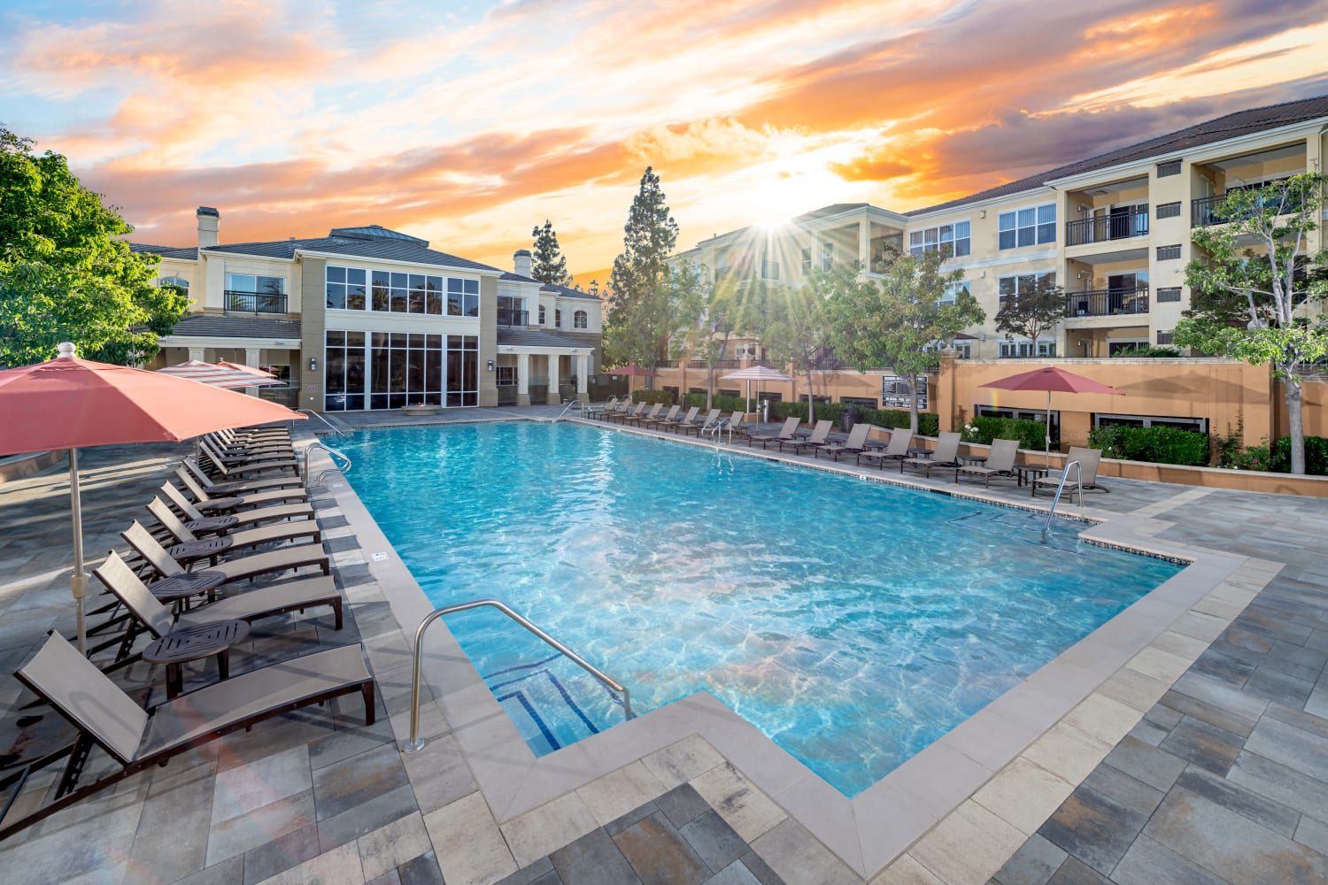 Exterior view of swimming pool and fire pit at The Carlyle Apartments in Santa Clara