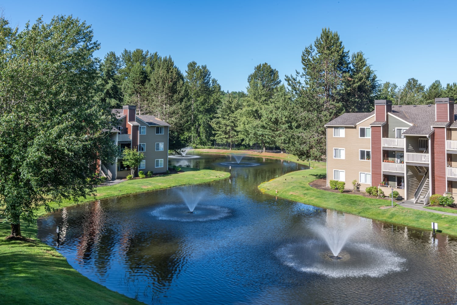 Exterior of community building with pond and fountain at The Preserve at Forbes Creek in Kirkland, Washington