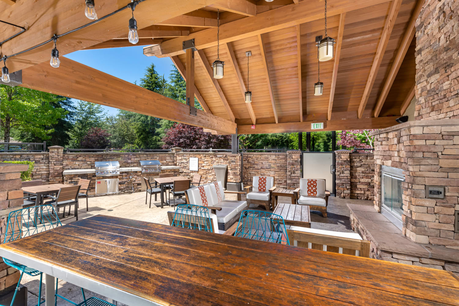 Outdoor covered grill station with community seating at The Preserve at Forbes Creek in Kirkland, Washington