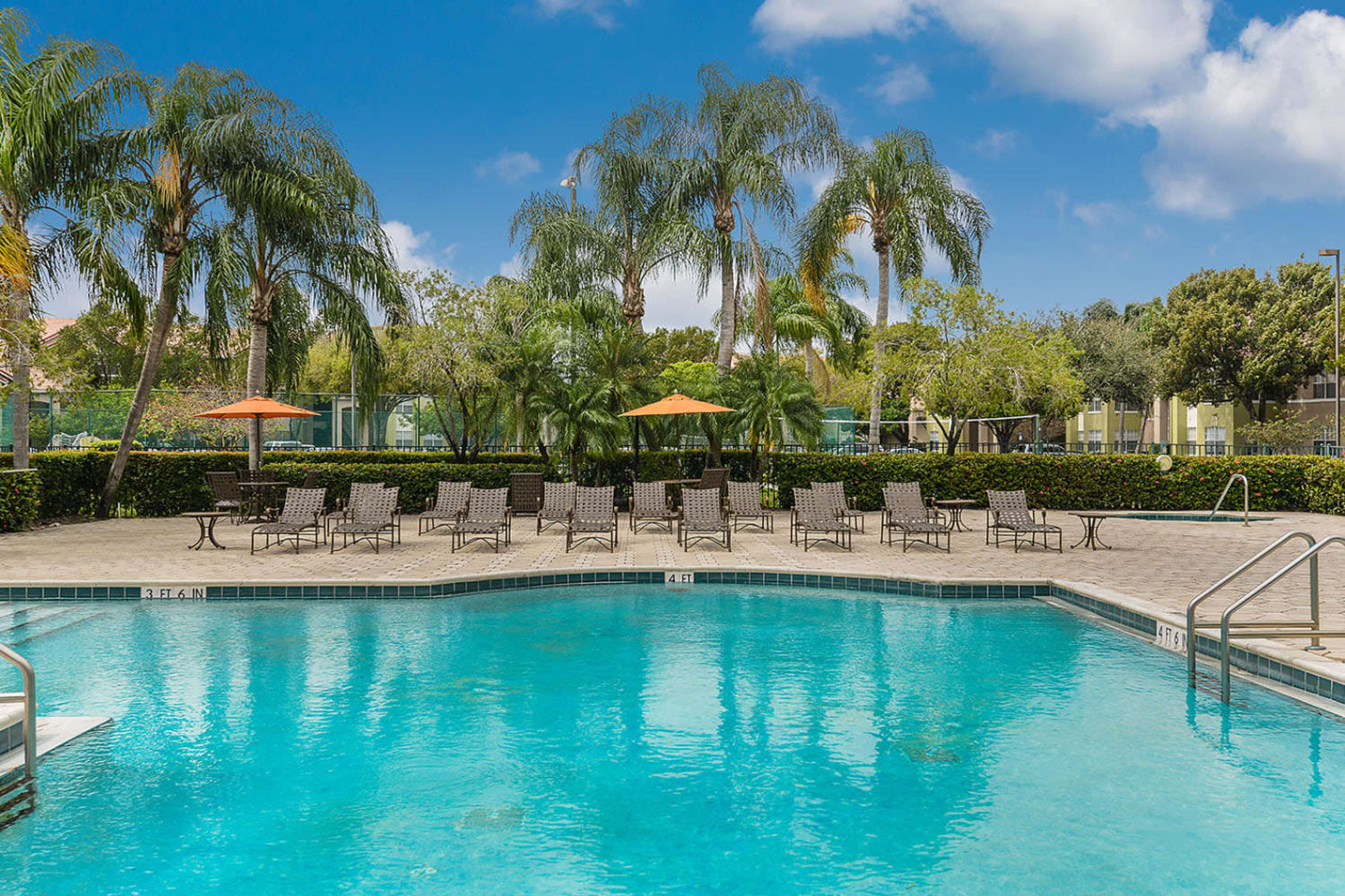 Pool with lounge chairs at Royal St. George at the Villages Apartment Homes in West Palm Beach, Florida