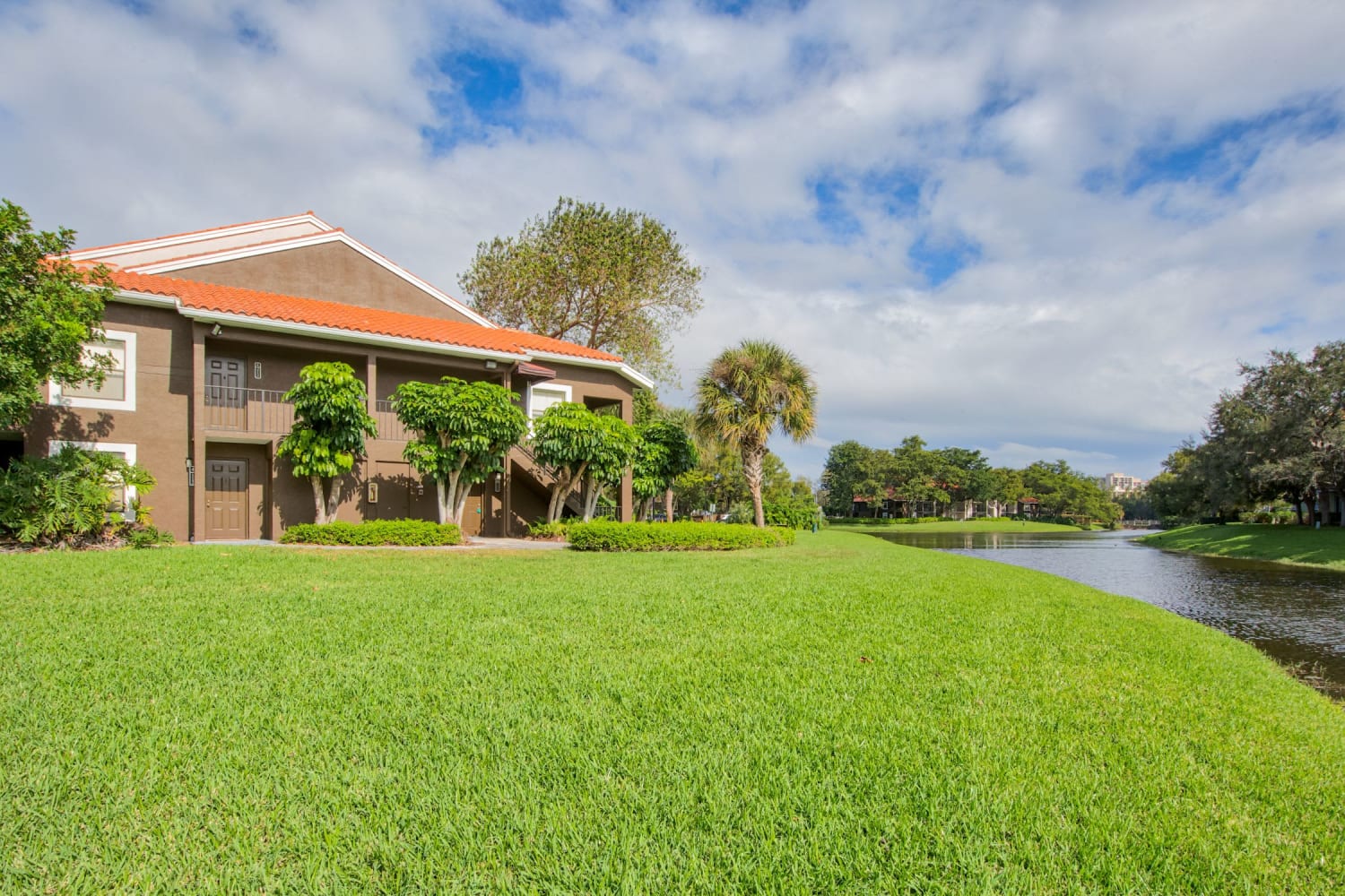 Large grassy lawn and lake at Village Place Apartment Homes in West Palm Beach, FL