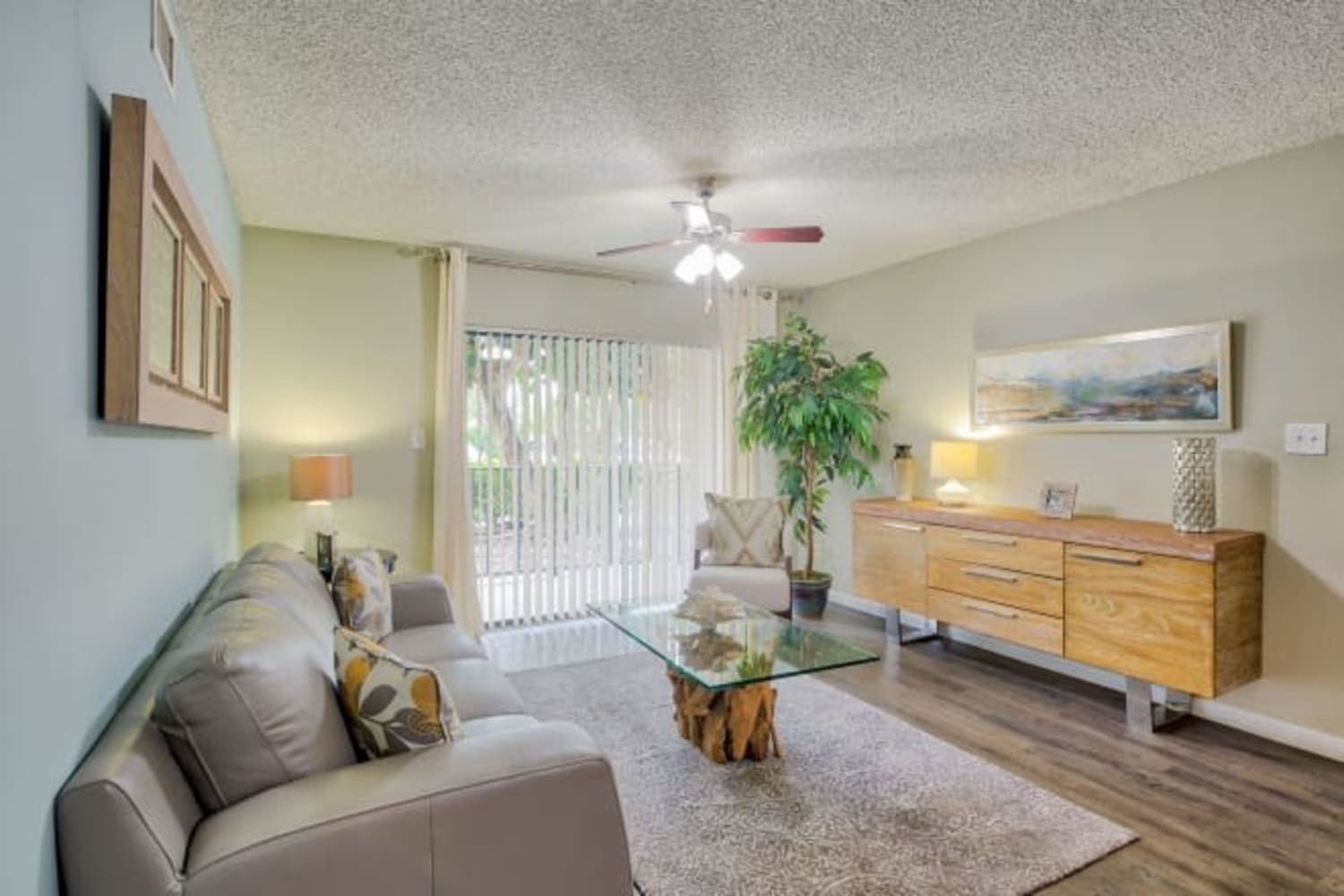 Spacious living room with door to patio at Village Place Apartment Homes in West Palm Beach, Florida