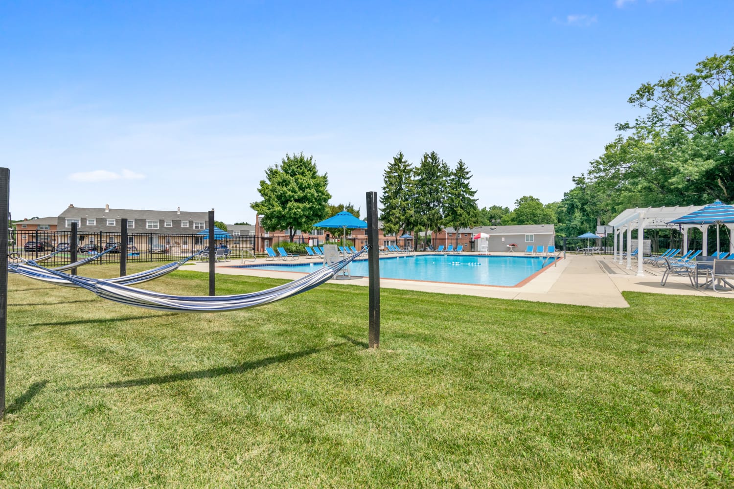 Outdoor swimming pool lunge area with hammocks at Roberts Mill Apartments & Townhomes in Maple Shade, New Jersey