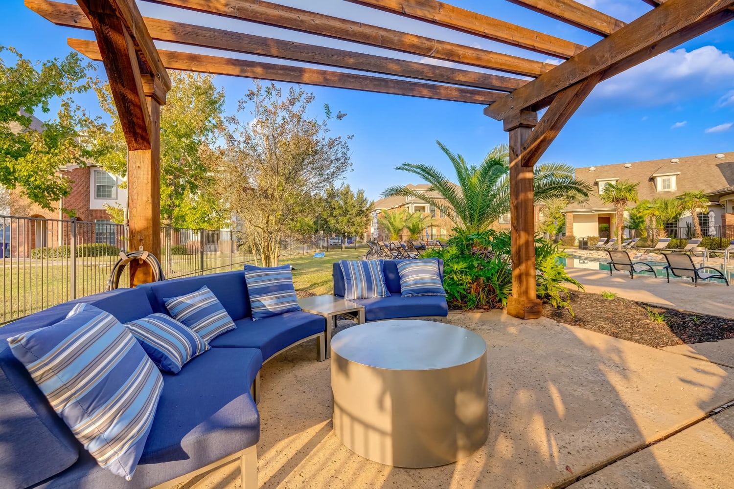 Comfortable outdoor seating with a fireplace under a gazebo at Chateau Mirage Apartment Homes in Lafayette, Louisiana