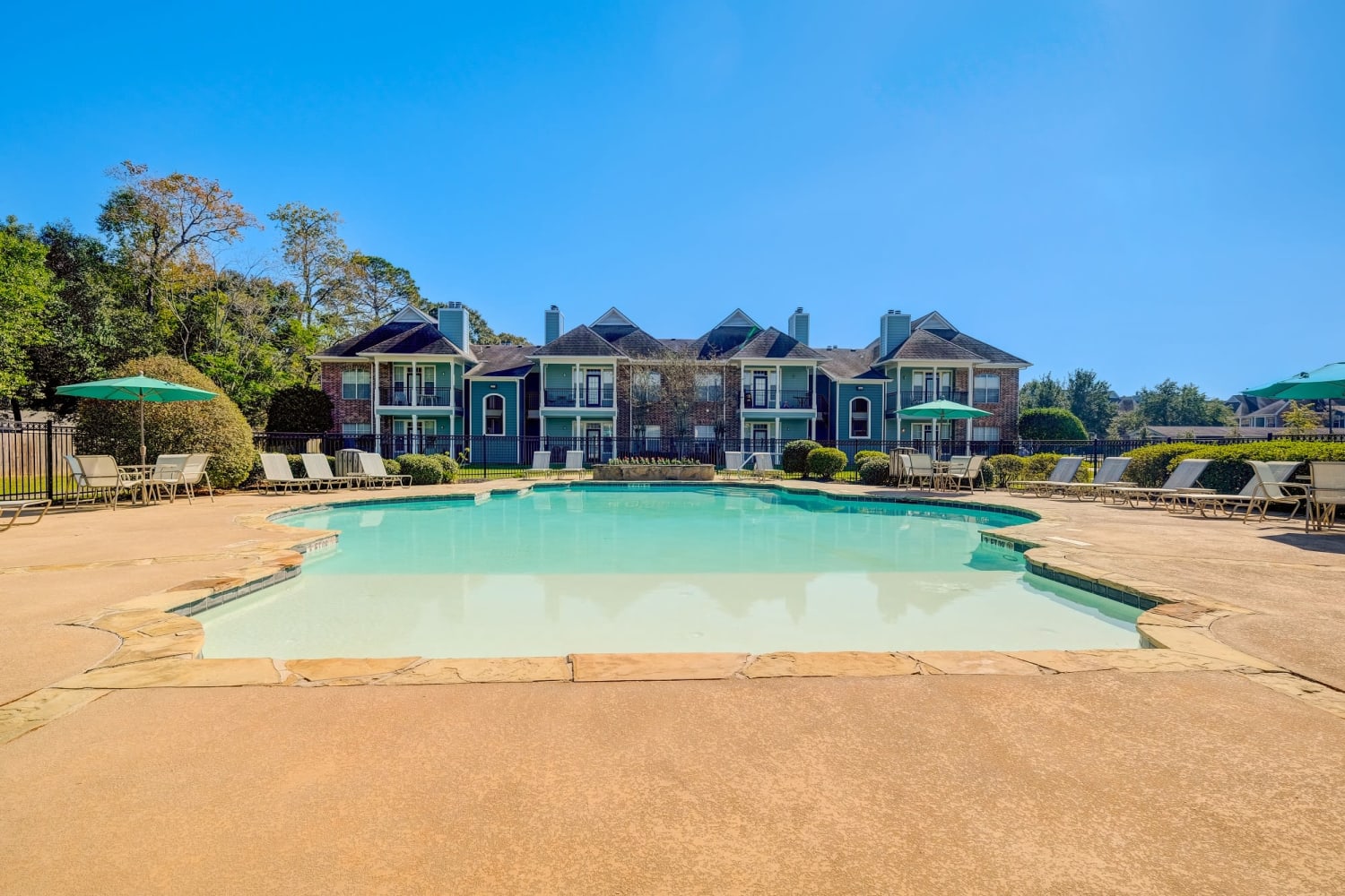 Exterior view of pool and patio at Audubon Apartments in Lafayette, LA