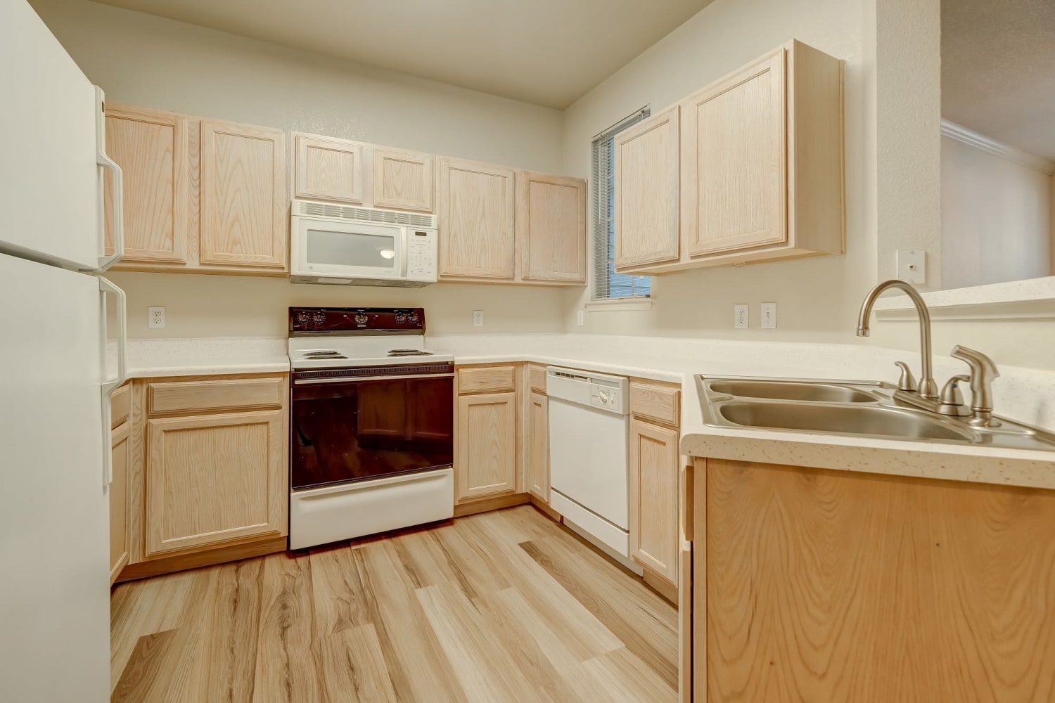 Kitchen with wood cabinets at Audubon Lake Apartment Homes in Lafayette, Louisiana